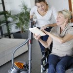 Young woman helping disabled lady at home